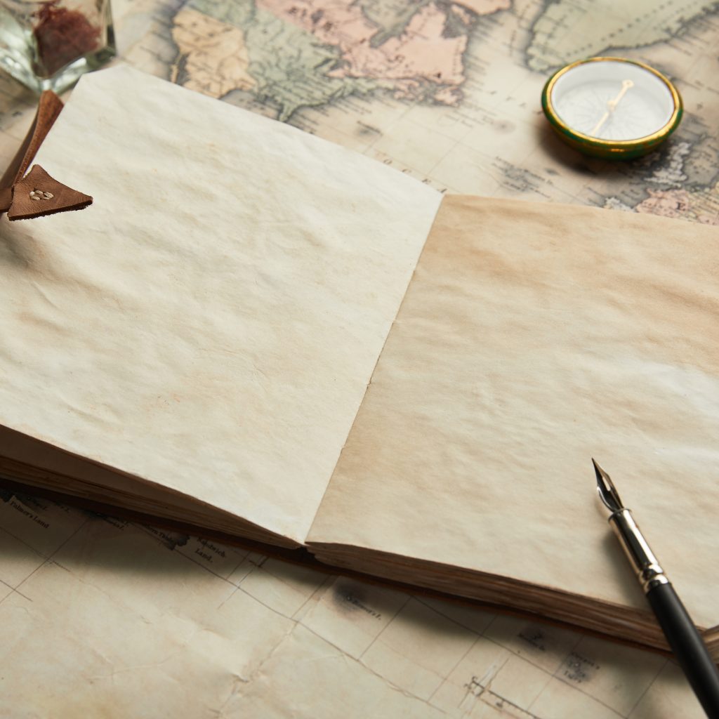 Vintage map and parchment papers with a leather bookmark and a magnifying glass on a desk. (informative)